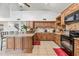 Open kitchen featuring granite counters, central island, tile floors, and modern black appliances at 7949 W Pershing Ave, Peoria, AZ 85381