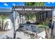 A custom outdoor kitchen and bar area under a pergola complete with barstool seating at 7949 W Pershing Ave, Peoria, AZ 85381