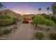 Beautiful home with a circular driveway surrounded by mature trees, desert landscaping, and mountain views at 8031 N 54Th St, Paradise Valley, AZ 85253