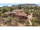 Rear exterior shot of home with brick and tile roof surrounded by desert vegetation and mountain views at 8031 N 54Th St, Paradise Valley, AZ 85253