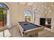 Bright game room features a pool table, stone fireplace, and large windows offering scenic views at 8031 N 54Th St, Paradise Valley, AZ 85253