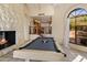 Charming game room showcases a pool table with a stone fireplace, plus views of the kitchen and backyard at 8031 N 54Th St, Paradise Valley, AZ 85253