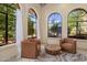 Cozy sitting area features two armchairs and a wooden table, complemented by natural light filtering through large windows at 8031 N 54Th St, Paradise Valley, AZ 85253