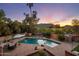 Relaxing pool area at sunset features lounge chairs, patio furniture, a well-maintained garden, and scenic mountain views at 8031 N 54Th St, Paradise Valley, AZ 85253
