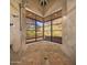 Luxurious tiled shower featuring a stunning view of the desert landscape through a large corner window at 8031 N 54Th St, Paradise Valley, AZ 85253