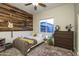Inviting bedroom with a rustic wood accent wall, guitar, and comfortable decor at 8544 W Mary Ann Dr, Peoria, AZ 85382