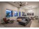 Spacious living room featuring a comfortable gray sectional couch, modern lighting, and a stylish accent chair at 8544 W Mary Ann Dr, Peoria, AZ 85382