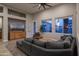 Cozy living room with gray sectional, accent chair, and backyard views at 8544 W Mary Ann Dr, Peoria, AZ 85382