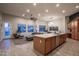 Open-concept living room featuring a gray sectional couch, modern lighting, and a view of the backyard at 8544 W Mary Ann Dr, Peoria, AZ 85382