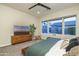 Serene main bedroom with backyard views, comfortable furnishings, and a large TV at 8544 W Mary Ann Dr, Peoria, AZ 85382