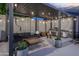 Covered patio with outdoor kitchen, firepit, and comfortable seating at 8544 W Mary Ann Dr, Peoria, AZ 85382