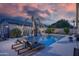 Backyard pool with lounge chairs, palm trees, and string lights providing a relaxing outdoor space at 8544 W Mary Ann Dr, Peoria, AZ 85382