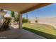 Backyard patio with privacy wall, small grassy lawn area, greenery, and partial shade at 8614 W Shaw Butte Dr, Peoria, AZ 85345