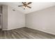 This bedroom features light gray walls, hardwood flooring, a ceiling fan, and an open floorplan at 8614 W Shaw Butte Dr, Peoria, AZ 85345