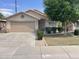 Charming single-story home with a well-manicured lawn, mature tree, and a two-car garage at 8614 W Shaw Butte Dr, Peoria, AZ 85345