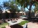 Enjoy this backyard with mature trees, artificial grass, and shaded seating area at 9203 W Behrend Dr, Peoria, AZ 85382