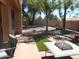 Spacious backyard with patio, seating, and lush trees at 9203 W Behrend Dr, Peoria, AZ 85382
