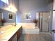 Bathroom featuring double sinks, vanity, standing shower and garden tub at 9203 W Behrend Dr, Peoria, AZ 85382