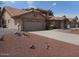 Charming home features a tile roof, two-car garage, and low-maintenance desert landscaping at 9203 W Behrend Dr, Peoria, AZ 85382