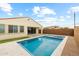 A gorgeous home exterior is complemented by a pristine backyard pool and travertine decking with synthetic grass at 9612 E Rainbow Ave, Mesa, AZ 85212