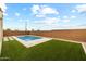 A backyard area featuring a pristine pool area, travertine decking, and lush artificial grass at 9612 E Rainbow Ave, Mesa, AZ 85212