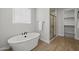 Modern bathroom with soaking tub, frameless glass shower and wood-look tile flooring at 9612 E Rainbow Ave, Mesa, AZ 85212
