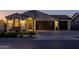 Charming single-story home with a three car garage, stucco siding and a tile roof at dusk at 9612 E Rainbow Ave, Mesa, AZ 85212