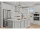 Modern white kitchen featuring stainless steel appliances, quartz countertops, and stylish pendant lighting at 9612 E Rainbow Ave, Mesa, AZ 85212