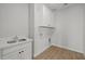 Functional laundry room with sink, white cabinetry and wood-look tile floors at 9612 E Rainbow Ave, Mesa, AZ 85212