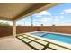 Covered patio overlooks the sparkling backyard pool, complete with travertine decking and synthetic grass at 9612 E Rainbow Ave, Mesa, AZ 85212