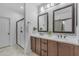 Elegant bathroom featuring double sinks, wood cabinets, and a glass-enclosed shower for a luxurious feel at 9853 E Solstice Ave, Mesa, AZ 85212