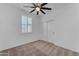 Bedroom featuring neutral carpet, a modern ceiling fan, and plantation shutters at 9853 E Solstice Ave, Mesa, AZ 85212