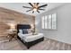 Inviting bedroom features a wood accent wall, plush carpet, ceiling fan, and bright window with plantation shutters at 9853 E Solstice Ave, Mesa, AZ 85212