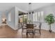 Bright dining area with wood floors, stylish lighting fixture, and a view of the charming outdoor patio at 9853 E Solstice Ave, Mesa, AZ 85212