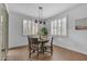 Inviting dining room with wood floors, modern lighting, and shuttered windows at 9853 E Solstice Ave, Mesa, AZ 85212