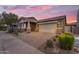 Charming single-story home featuring a large driveway, two-car garage, and meticulously landscaped front yard at 9853 E Solstice Ave, Mesa, AZ 85212