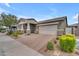 Charming single-story home featuring a large driveway, two-car garage, and meticulously landscaped front yard at 9853 E Solstice Ave, Mesa, AZ 85212