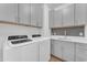 A practical laundry room with ample cabinet space, counter, and a sink at 9853 E Solstice Ave, Mesa, AZ 85212