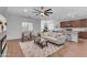Spacious living room featuring wood floors, neutral decor, modern fireplace, and seamless flow to kitchen at 9853 E Solstice Ave, Mesa, AZ 85212