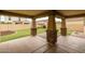 Covered back patio features decorative stone pillars and a spacious artificial grass backyard at 9911 E Telemetry Dr, Mesa, AZ 85212