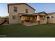 Backyard featuring artificial grass lawn and covered patio with stone pillars at 9911 E Telemetry Dr, Mesa, AZ 85212