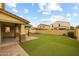 Backyard featuring a covered patio with decorative stone pillars and artificial grass at 9911 E Telemetry Dr, Mesa, AZ 85212