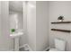 Small powder room with a pedestal sink, two floating shelves, and toilet at 9911 E Telemetry Dr, Mesa, AZ 85212