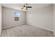 Neutral bedroom offers a ceiling fan, plush carpet, and a bright window with neighborhood views at 9911 E Telemetry Dr, Mesa, AZ 85212
