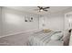 Cozy bedroom boasts a ceiling fan, plush bedding, and an open doorway to a walk-in closet at 9911 E Telemetry Dr, Mesa, AZ 85212