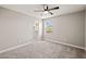 Well-lit bedroom with a ceiling fan and a closet, with bright windows offering neighborhood views at 9911 E Telemetry Dr, Mesa, AZ 85212