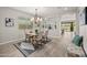 Well-lit dining area featuring stylish chairs, a modern light fixture, and wood-look flooring at 9911 E Telemetry Dr, Mesa, AZ 85212