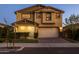 Two-story home features attached two car garage, stucco facade, and manicured front yard at dusk at 9911 E Telemetry Dr, Mesa, AZ 85212