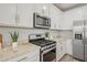 Kitchen featuring stainless steel appliances, white cabinetry, and granite countertops with tile backsplash at 9911 E Telemetry Dr, Mesa, AZ 85212