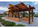 Community outdoor fireplace and ramada provides seating and shade amongst beautifully landscaped surroundings at 9911 E Telemetry Dr, Mesa, AZ 85212